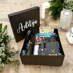 This personalized Rakshabandhan hamper for Aditya is filled with his favorite things. It includes a custom tumbler, vegan leather accessories, a photo frame, and snacks, all in a beautiful black gift box.