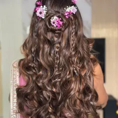 A bohemian-inspired look perfect for a Mehendi or Haldi. I combined soft waves with delicate braids and a floral crown made of fresh pink and white flowers for a romantic and playful hairstyle.