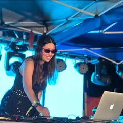 In my element, mixing tracks under the bright lights of an outdoor festival stage. This is a glimpse of my setup and focus during a high-tempo set, ensuring a seamless flow of music for the party.