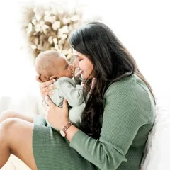 The special bond between a mother and her newborn. This bright, airy portrait captures a moment of quiet connection and adoration in our natural light studio.
