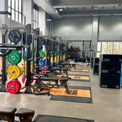 An expansive view of our High-Performance Center, equipped with Hammer Strength racks, an indoor running track, and everything an athlete needs for comprehensive strength and conditioning.