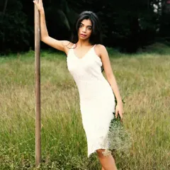 A classic, elegant pose against a wooden pole, with the lush green field stretching out behind.