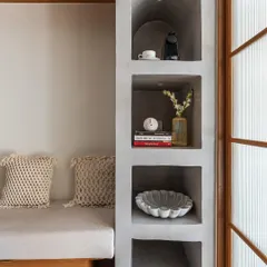 I love creating built-in features like this arched concrete shelving unit. It adds architectural interest and provides a beautiful, minimalist space to display books and decor, enhancing the clinic's calm, Japandi-inspired feel.