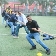 The fun isn't just for kids. Dads join in for a spirited game of tug-of-war during a football-themed party, showing that everyone can be a part of the action.