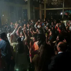 Another perspective of the high-energy reception dance floor. The dramatic lighting and the crowd's excitement make for a dynamic and memorable photograph.
