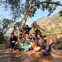 A happy group photo on a wooden deck overlooking the mountains. The shared adventure and stunning scenery bring us closer together as a community.