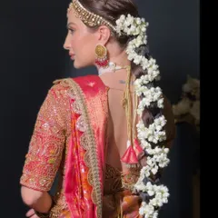 A side view of a stunning South Indian bridal braid, heavily adorned with traditional jasmine flowers. This hairstyle is a beautiful tribute to cultural heritage and timeless beauty.