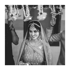 A timeless black and white portrait of a North Indian bride under her 'phoolon ki chadar' (floral canopy).