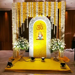 The focal point for a Sai Sandhya, featuring an idol of Sai Baba set within a beautifully crafted floral backdrop of yellow petals and an ornate white jali arch.