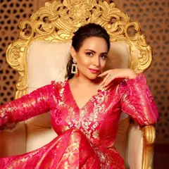 A close-up on the throne, highlighting the flawless, dewy skin and the soft, shimmering eye makeup. The look is fit for royalty.