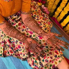 A top-down view of Sahana's complete bridal mehendi, showcasing the intricate work on her hands and arms.