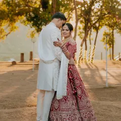 A sundowner wedding in the hills of Jim Corbett. The golden light filtering through the trees creates a magical, romantic glow around the couple in their stunning wedding attire.