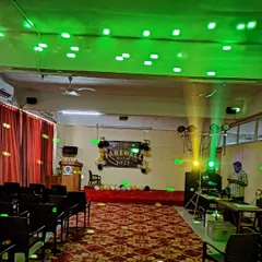 A farewell party setup showing my DJ station, speakers, and party lights. The green laser lights create a fun, energetic atmosphere on the dance floor.