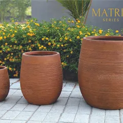 The MATRIX series offers a distinct horizontal texture, shown here in a warm terracotta finish. These barrel-shaped FRP planters add a rustic yet refined touch to gardens, balconies, and indoor spaces.