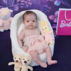 This little one is ready for her close-up in a Barbie-themed newborn shoot, complete with a fluffy chair and tiny teddy bears.