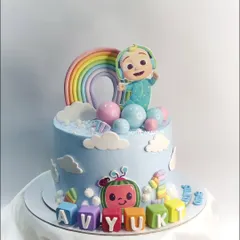 This elegant Cocomelon theme cake features pastel colors and cute, edible details like the character blocks. It was paired with matching rainbow cupcakes for a complete party set.