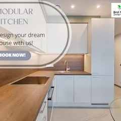 This kitchen combines white handleless cabinets with a warm wood-finish countertop and backsplash. The design is minimalist, functional, and easy to maintain.