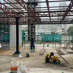 On-site at Heritage Xperiential School, workers assemble the metal truss for the entrance. This phase is critical, as the raw materials and structural connections begin to reveal the tangible form of our design intent.