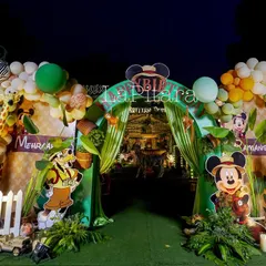 Adventure awaits at this Mickey Mouse jungle safari entrance. As night falls, the lighting brings the entire scene to life, highlighting the vibrant balloon arch, playful character cutouts, and lush greenery. This setup shows how I create an exciting and immersive atmosphere that captivates guests of all ages.