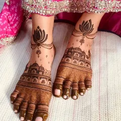 A royal foot design featuring architectural motifs on the feet and a delicate lotus 'payal' or anklet design.