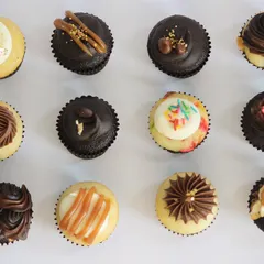 A top-down view of my TBC Minis, showcasing the variety of flavours and designs available in a single assorted box. From Kesar Badam Pista to Nutty Chocolatey, each bite-sized cupcake is a unique experience.