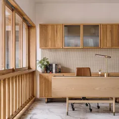 This home office in Cocoon House is a study in texture and light. We used fluted wood for the cabinetry and a pegboard-style backsplash, creating a tactile and organized workspace. The large window with wooden mullions allows natural light to flood the room, making it a calm and inspiring place to work.
