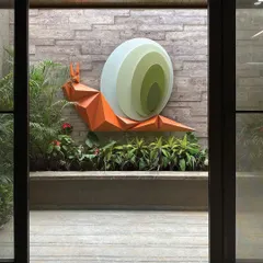 Viewed through a doorway, the snail installation becomes a piece of framed art. It is designed to create a sense of symbiosis with its surroundings, blurring the line between sculpture and garden.