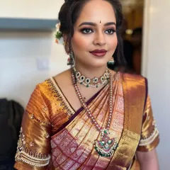 This profile shot showcases the flawless finish of the makeup and the elegant hairstyle. The makeup is designed to look stunning from every angle, ensuring you are picture-perfect all day.