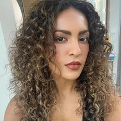 I love bringing curls to life with color. For this look, I hand-painted caramel blonde highlights to define her natural curl pattern, creating beautiful dimension while keeping the hair healthy.