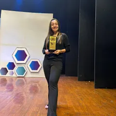 Proudly holding my award on the Choreofeast stage. This validates my skills not just as a dancer, but as a professional choreographer for events and competitions.