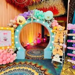 For a child's birthday, I bring their dreams to life. This butterfly-themed party entrance features a custom circular arch with lights, surrounded by colorful balloons and adorable teddy bears, creating a magical welcome for guests.