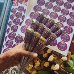 A fresh batch of my handmade henna cones, ready to create beautiful art. I hold them here with my own branded stickers in the background, which I place on every cone as a mark of authenticity.