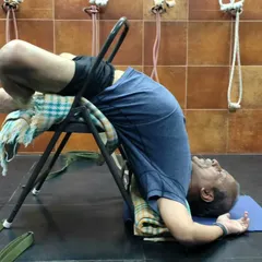 A supported backbend over a chair.
