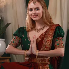 A respectful and graceful portrait featuring a model in a traditional South Indian half-saree, posed in a 'namaste' gesture. This shot beautifully blends cultural reverence with elegance.