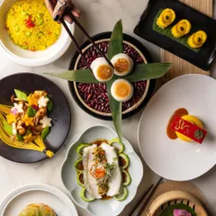 A fine-dining Pan-Asian spread is like a work of art. This top-down shot captures the beautiful plating and vibrant colours of each dish, from dumplings to steamed fish, creating a visual feast.