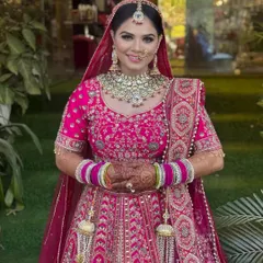 A full-length shot of this stunning bride in her bright pink lehenga. Her smile is infectious, and her makeup is designed to be radiant and long-lasting for the entire celebration.