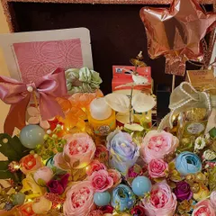 A full view of the stunning floral birthday hamper. It's packed with flowers, skincare, a mini balloon, and other treats, all nestled in a beautiful rose gold glitter box.