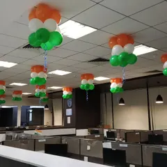 A wide view of an office space decorated with hanging tricolor balloon arrangements. We can scale our decorations to cover large floors and multiple cubicle sections.