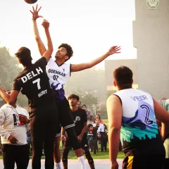 A classic jump ball situation, capturing the peak of action as two players compete for possession. This image shows the athleticism and competitive spirit that defines our games.