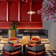 An intimate dining nook at Foo, where the red paneled walls and focused lighting create a cozy corner perfect for small groups.