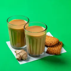 Two glasses of Indian masala chai with ginger and biscuits. This shot for Bistro by Blinkit evokes a sense of comfort and tradition.