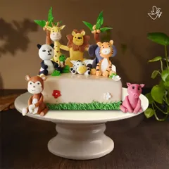 A whole jungle party on one cake. This design features a lion, giraffe, panda, tiger, elephant, monkey, and pig, all handcrafted from fondant for a wild celebration.