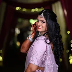 The pure joy of a reception-ready bride. For Isha's celebration, we went with a glamorous yet elegant look, featuring a bold red lip and soft, radiant makeup that complemented her lavender lehenga and let her personality shine.