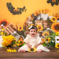 A happy baby girl surrounded by sunflowers. This theme is perfect for a bright, cheerful, and nature-inspired milestone session.