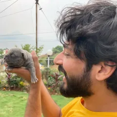 A fun moment holding a tiny newborn puppy. This shows my softer, playful side and my love for animals.