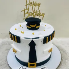 Adventure awaits, captain! A sharp and professional-looking cake designed as a pilot's uniform, complete with epaulets, a tie, and a captain's hat.