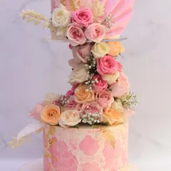 This floating floral cake creates a sense of magic and romance. The two tiers are separated by a cascade of fresh roses in soft pastel shades, making it a truly showstopping piece for a modern wedding.