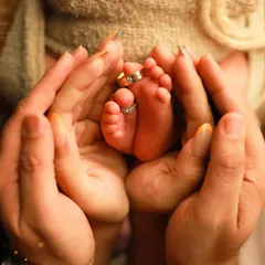 It's all about the tiny details. We love creating shots that show the scale of how small your baby is, like this image of parents' hands cradling their newborn's feet, with their wedding rings slipped onto the toes. It’s a powerful symbol of family and love.