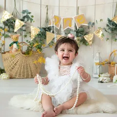 A purely joyful moment from a sitter session. This little girl's delighted laugh while playing with a string of pearls is what I love to capture.