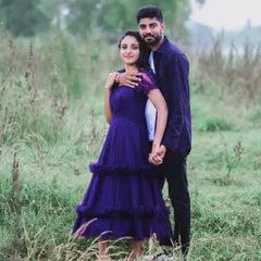 A couple enjoying a walk in nature for their pre-wedding shoot. The woman is wearing a lovely tiered purple dress from my rental collection, which is both comfortable and stylish.